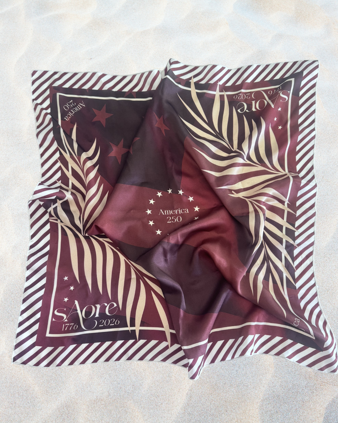 Maroon scarf with star and leaf pattern on a white background