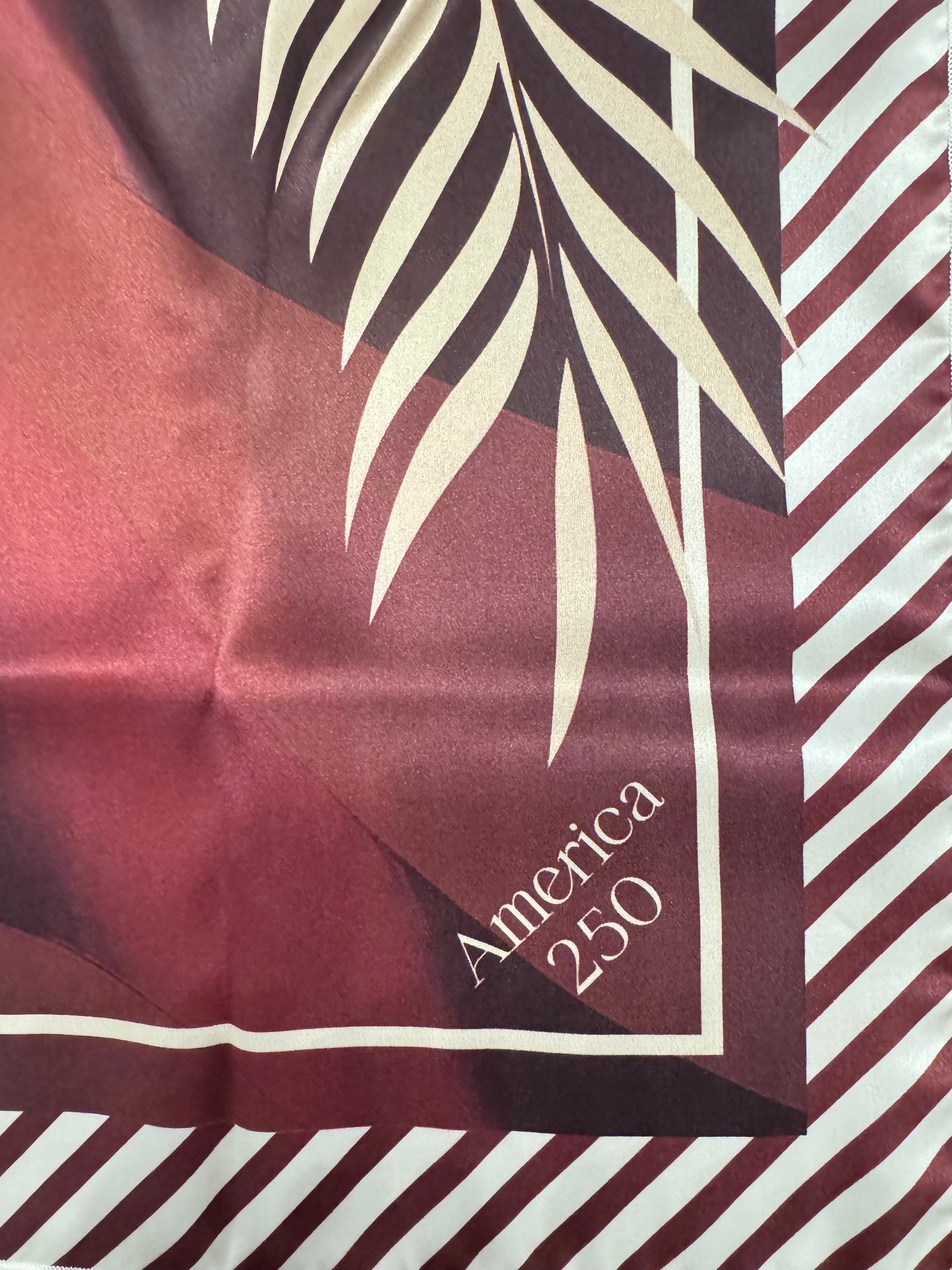 Satin fabric with leaf pattern and 'America 250' text on a red and white striped background